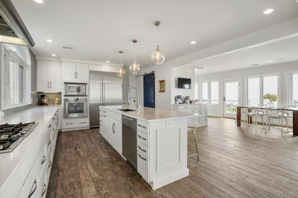 123 Gurnet Road Duxbury, MA 02332 - Photo 10 of 42 a large kitchen with kitchen island a stove a sink a refrigerator and white cabinets with wooden floor