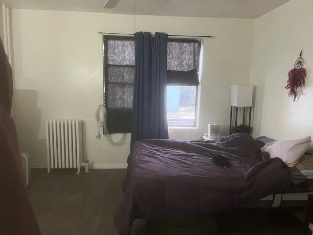 a bed sitting in a bedroom next to a window and chair