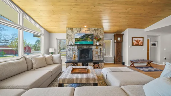 a living room with fireplace furniture and a large window