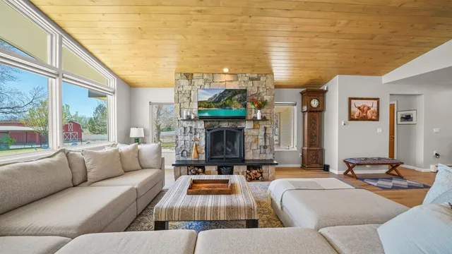a living room with fireplace furniture and a large window