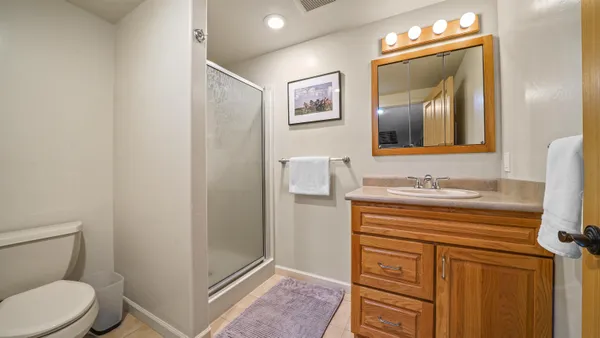 a bathroom with a granite countertop sink toilet and mirror