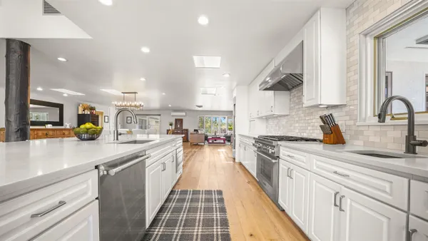 a large kitchen with stainless steel appliances lots of counter space and a sink