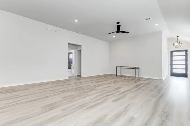 a view of an empty room with window and wooden floor