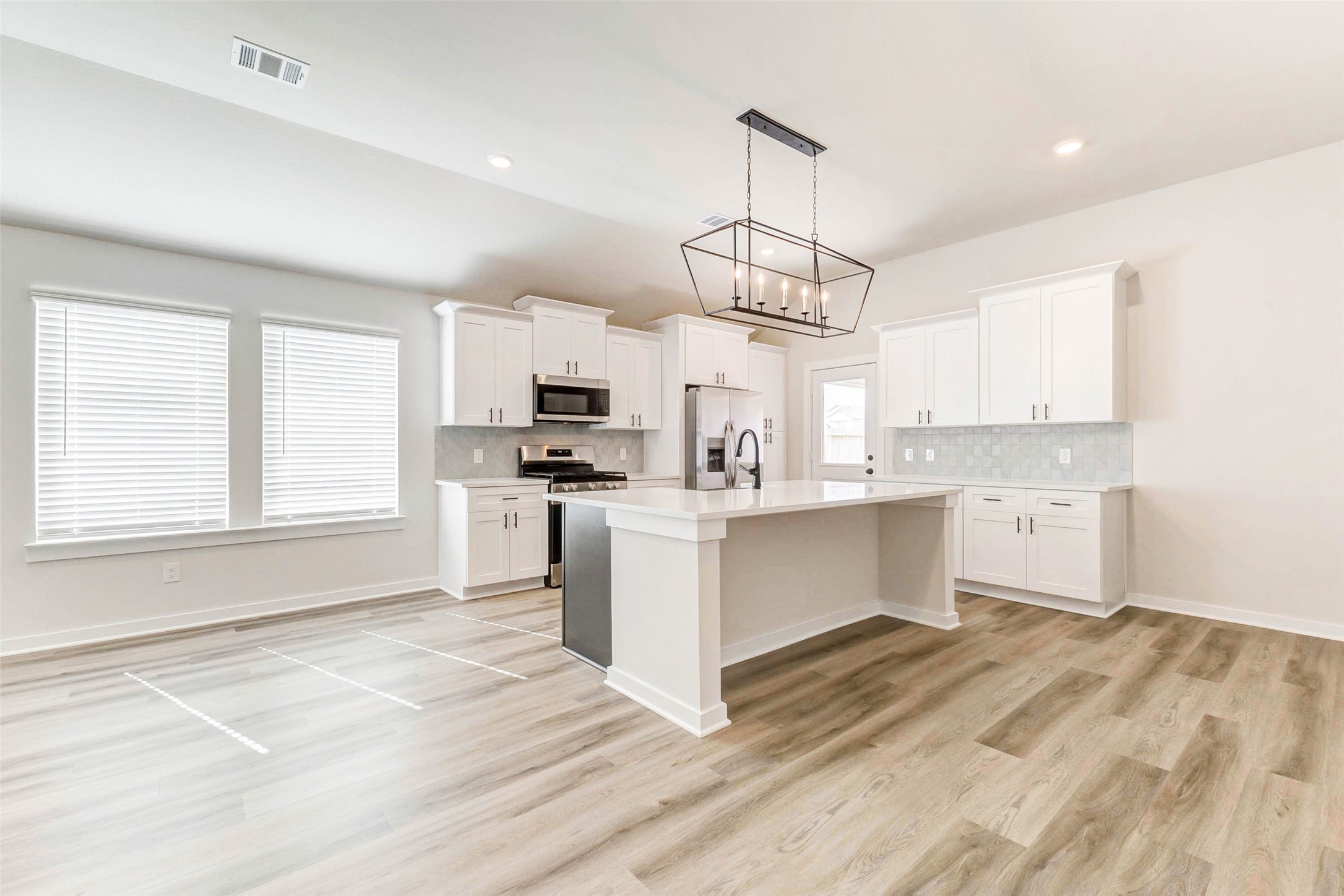 6422 Pomona Court Rosharon, TX 77583 - Photo 6 of 24 a large kitchen with kitchen island a large counter top a sink stainless steel appliances and cabinets
