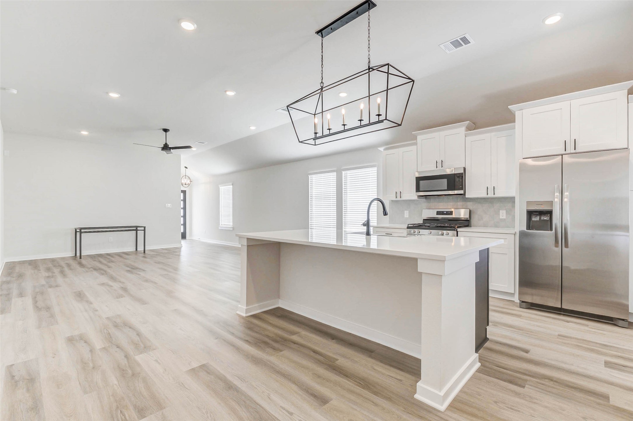 6422 Pomona Court Rosharon, TX 77583 - Photo 7 of 24 a kitchen with kitchen island stainless steel appliances a table chairs refrigerator and microwave