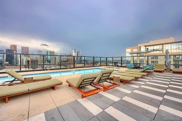 a roof deck with couches and potted plants