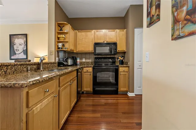a kitchen with stainless steel appliances granite countertop a refrigerator and a sink