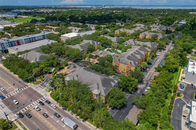 an aerial view of residential houses with outdoor space and trees