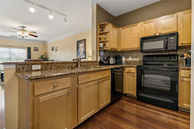 a kitchen with stainless steel appliances granite countertop a stove a sink and a microwave