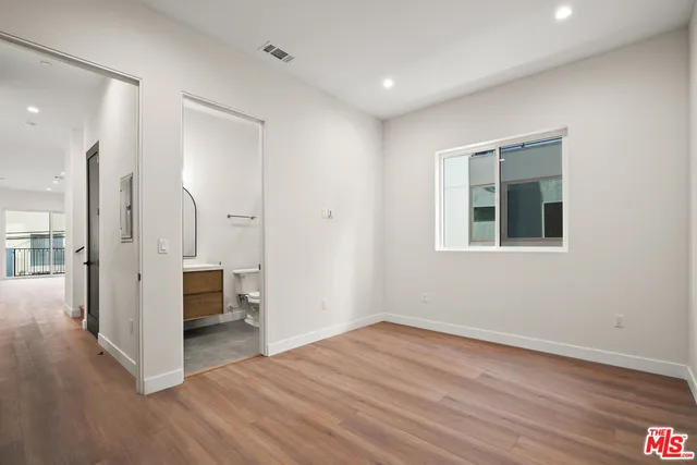 a view of a hallway with wooden floor and a living room