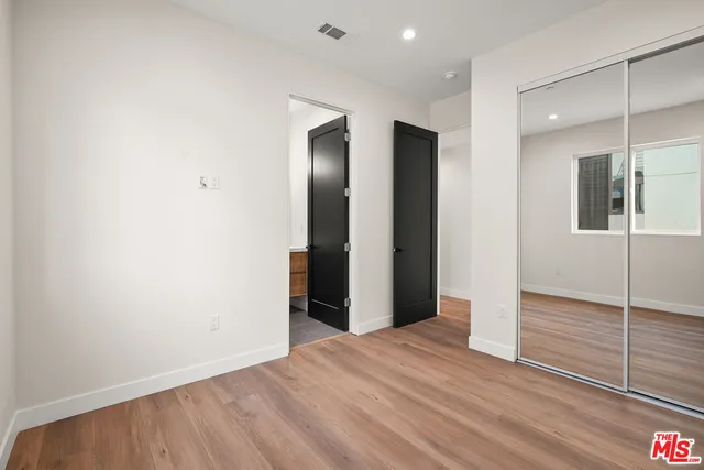an empty room with wooden floor and mirror