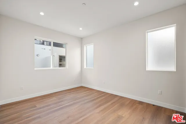 a view of empty room with wooden floor