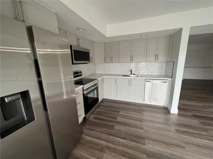 a kitchen with granite countertop a refrigerator stove and sink