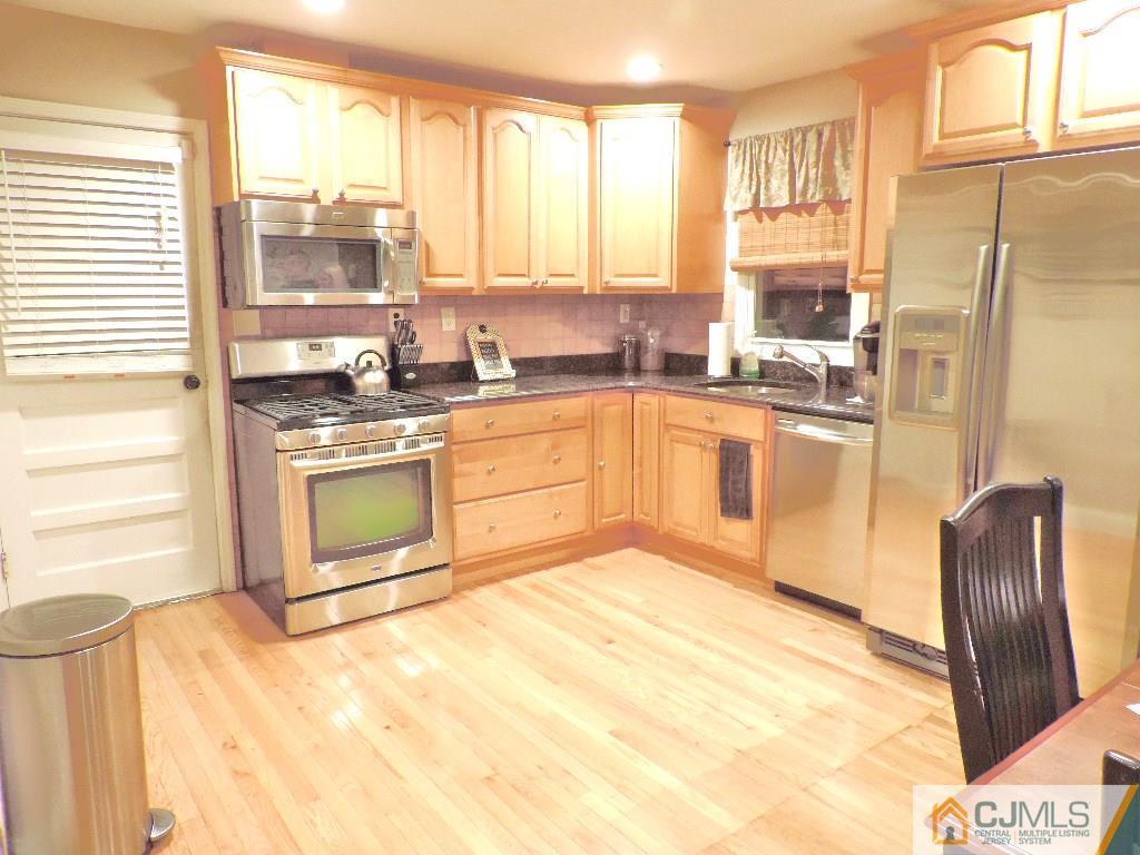 27 Columbia Road Old Bridge, NJ 08859 - Photo 3 of 24 a kitchen with stainless steel appliances granite countertop a stove a sink and a microwave