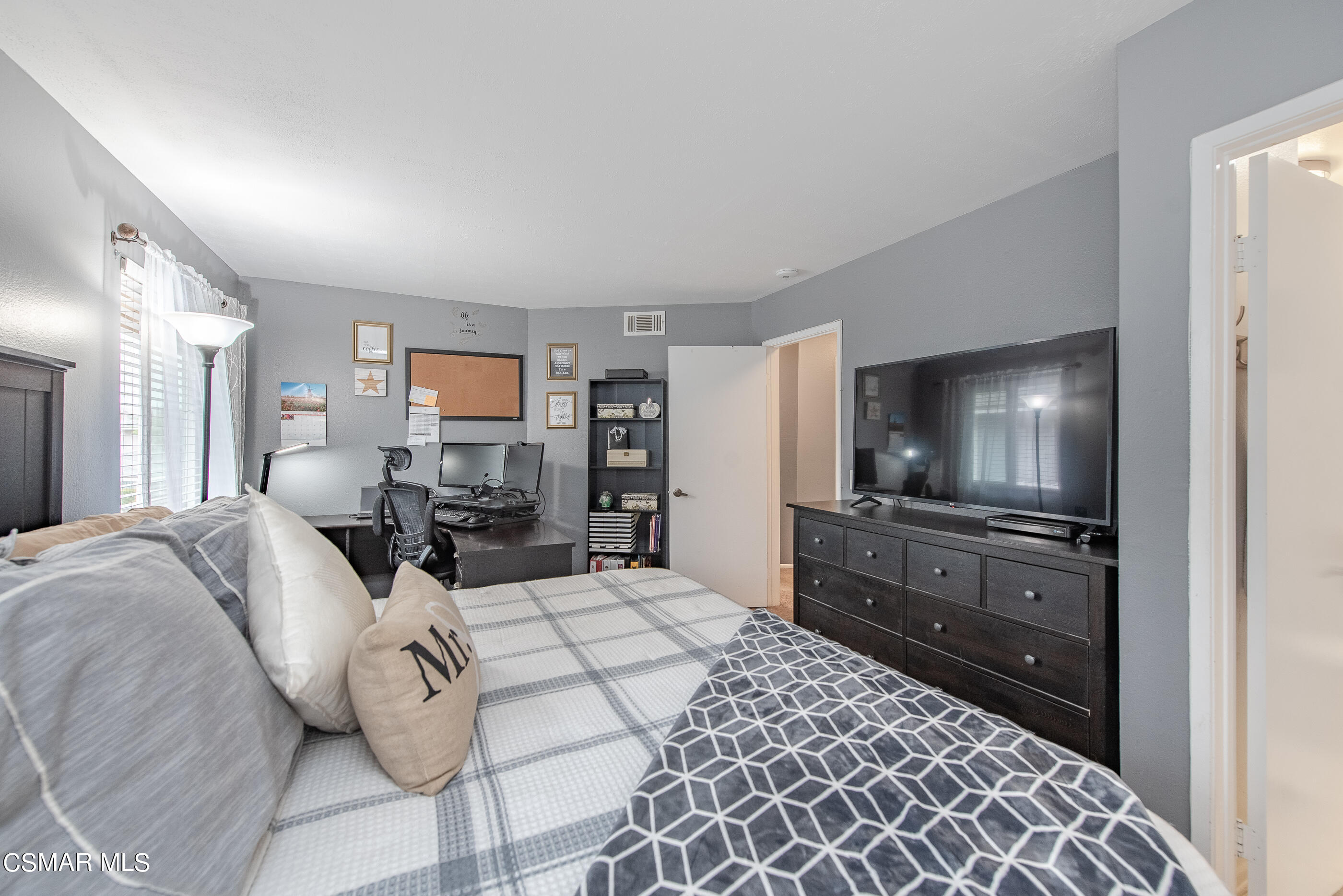 552 Spring Road, Unit 87 Moorpark, CA 93021 - Photo 20 of 29 a large bedroom with a bed and flat tv screen on the dresser