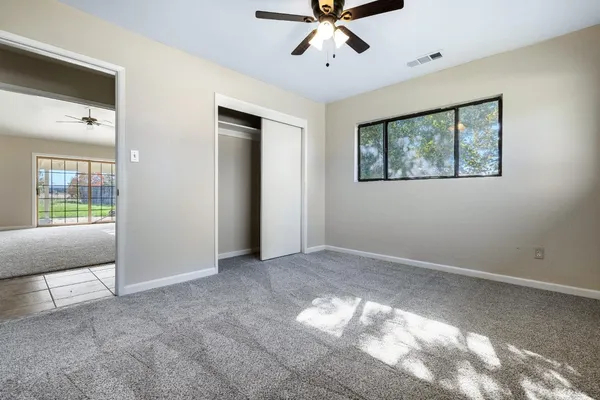 a view of a livingroom with a ceiling fan and window