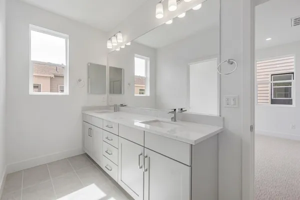 a bathroom with a granite countertop double vanity sink a mirror and a