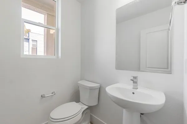 a bathroom with a sink a toilet and a mirror