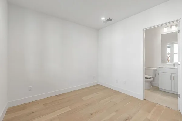 a view of a kitchen with white wooden cabinets and sink