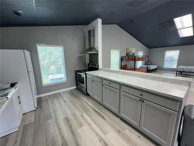 a kitchen with a stove and a wooden floor