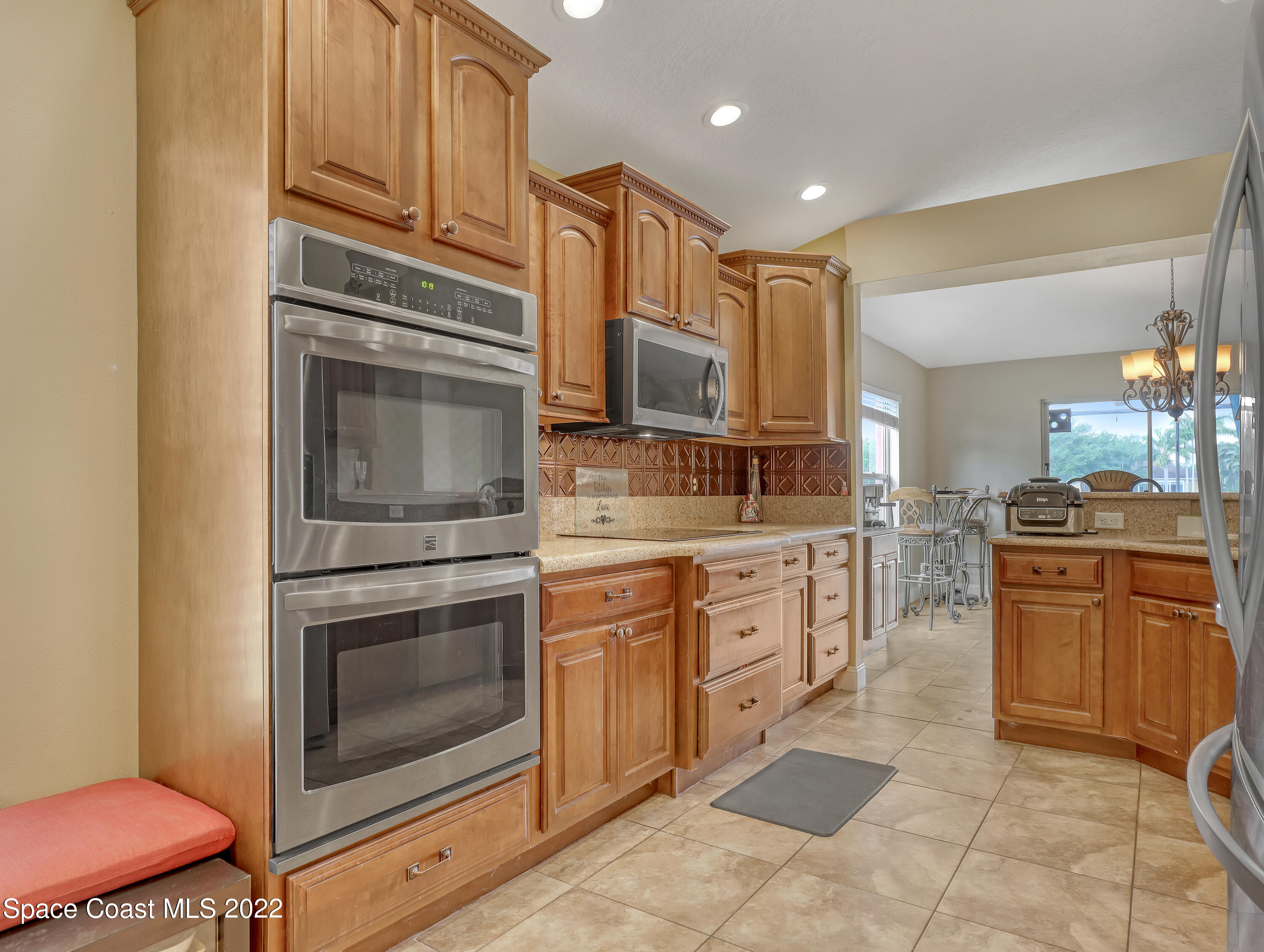 3935 Orion Way Rockledge, FL 32955 - Photo 7 of 30 a kitchen with stainless steel appliances granite countertop a stove microwave and cabinets