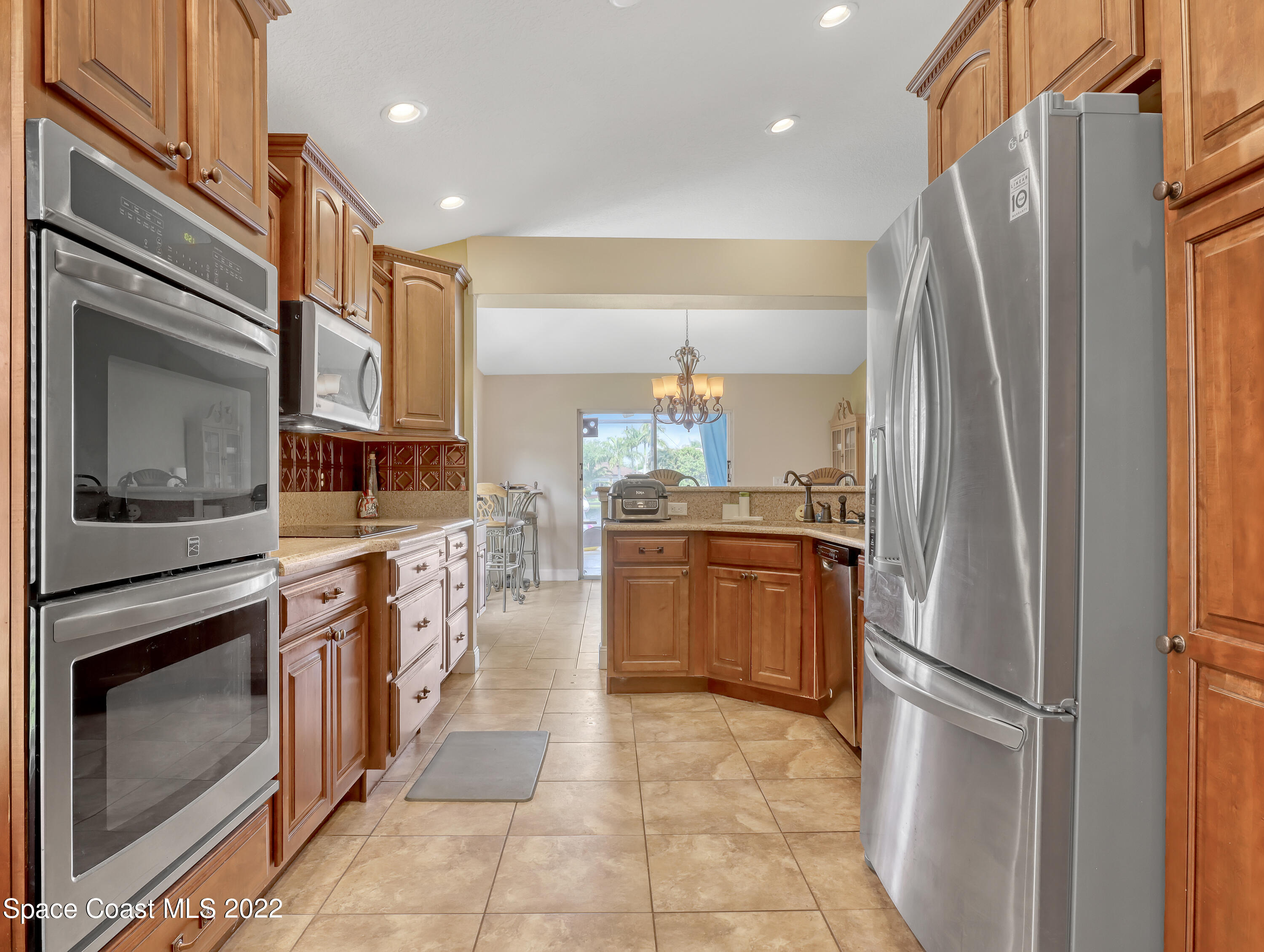 3935 Orion Way Rockledge, FL 32955 - Photo 10 of 30 a kitchen with stainless steel appliances granite countertop a refrigerator a stove and a sink