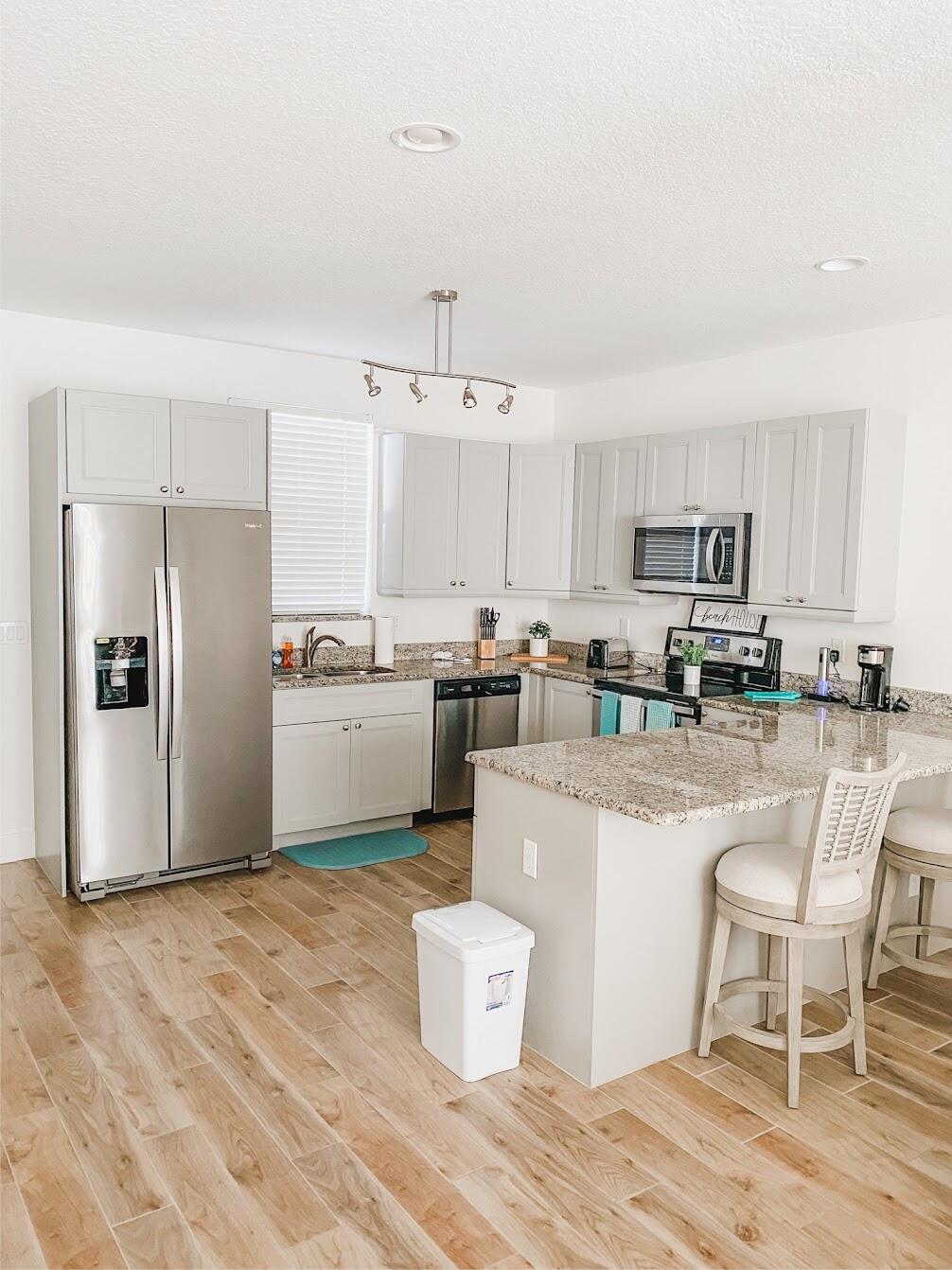 103 Osprey Circle Hypoluxo, FL 33462 - Photo 12 of 27 a kitchen with stainless steel appliances granite countertop a refrigerator sink and cabinets
