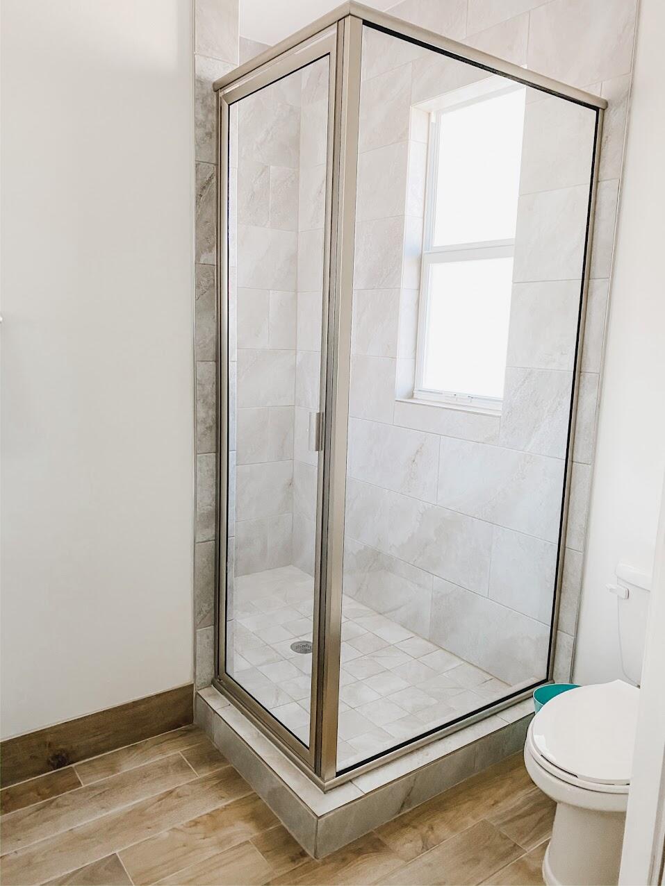 103 Osprey Circle Hypoluxo, FL 33462 - Photo 2 of 27 a bathroom with a glass shower door