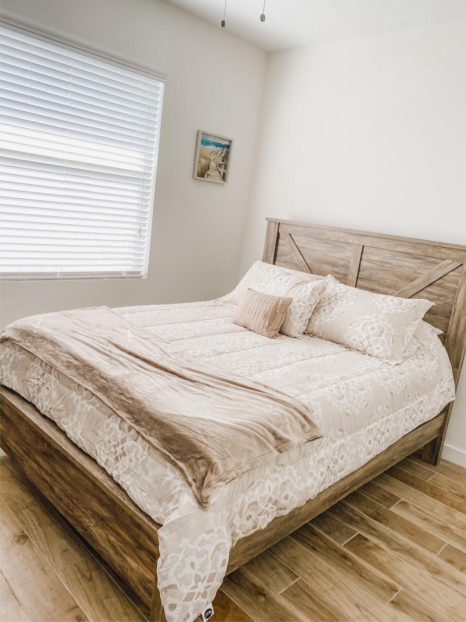 103 Osprey Circle Hypoluxo, FL 33462 - Photo 24 of 27 a bedroom with a bed and a night stand