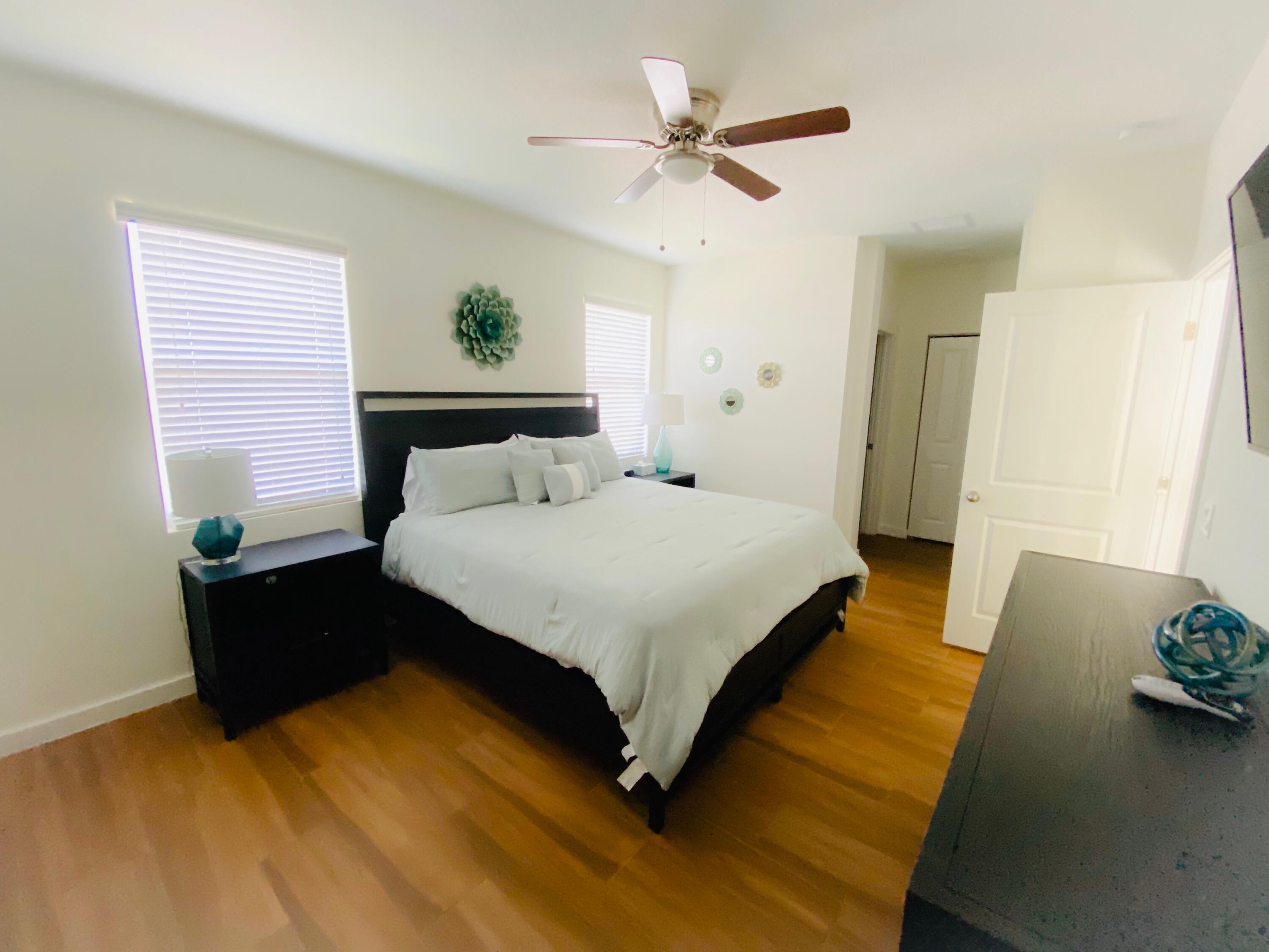 103 Osprey Circle Hypoluxo, FL 33462 - Photo 4 of 27 a spacious bedroom with a bed and wooden floor