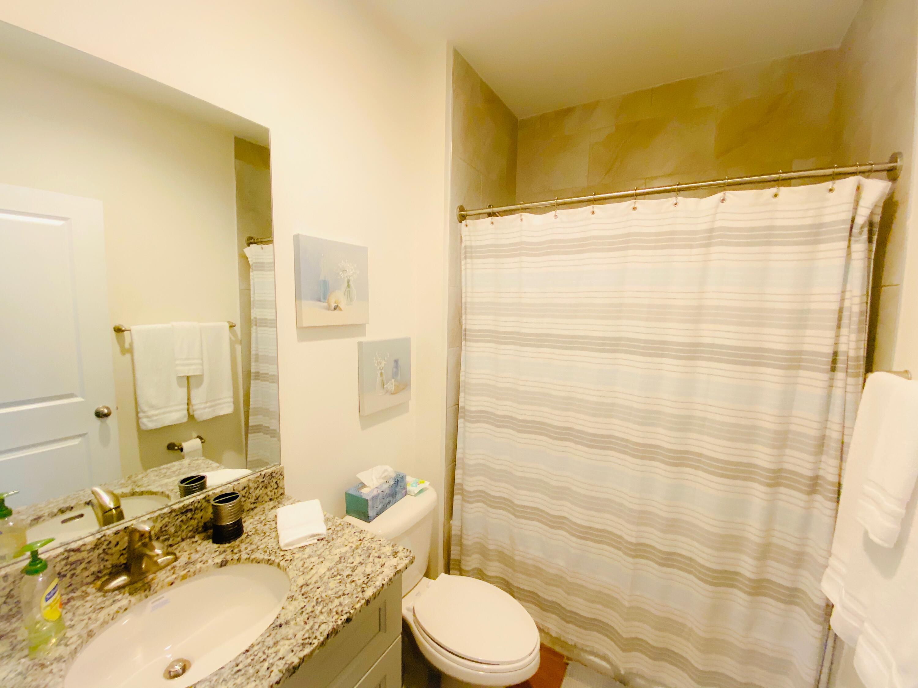 103 Osprey Circle Hypoluxo, FL 33462 - Photo 10 of 27 a bathroom with a granite countertop sink toilet and shower