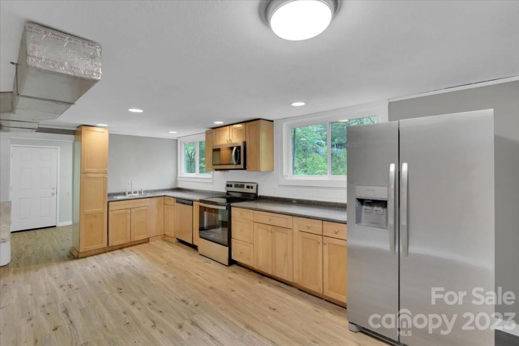 62 Kinard Lane Penrose, NC 28766 - Photo 20 of 25 a large kitchen with a refrigerator a sink dishwasher a stove and a refrigerator with wooden floor