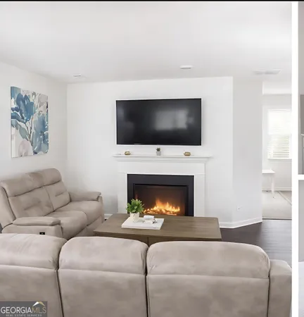 a living room with furniture a fireplace and a flat screen tv