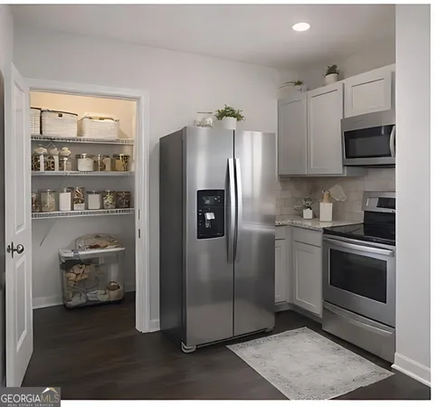 a kitchen with stainless steel appliances granite countertop a refrigerator a stove and a sink