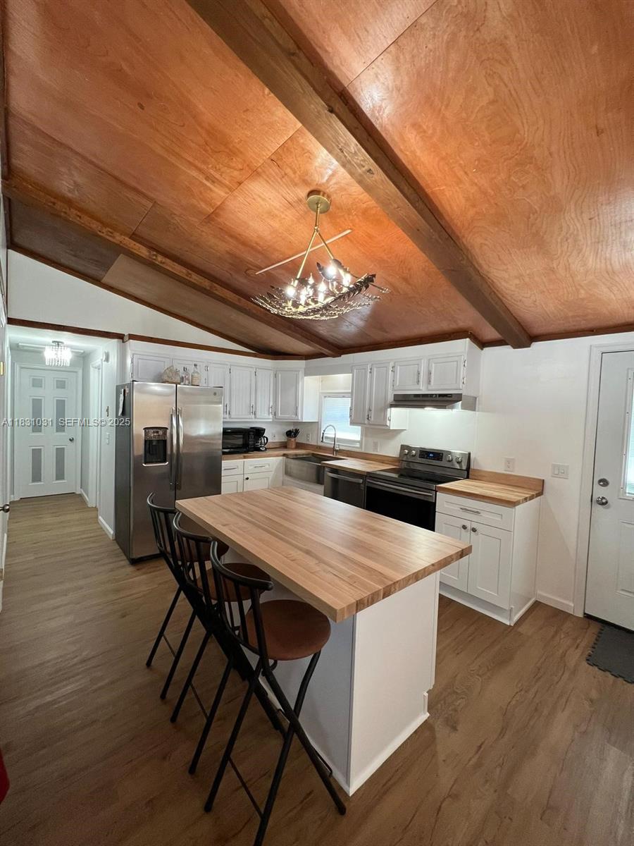 123 Rocky Road Lackawaxen, PA 18435 - Photo 13 of 39 a kitchen with stainless steel appliances a table chairs and wooden floor
