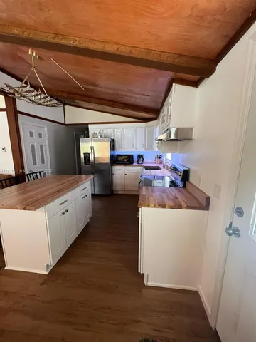 a kitchen with stainless steel appliances granite countertop a sink a stove and a refrigerator