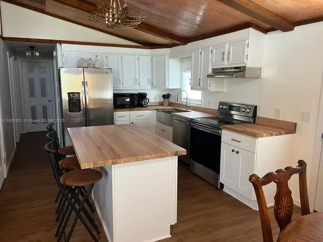 a kitchen with a table chairs wooden floors and a view of kitchen