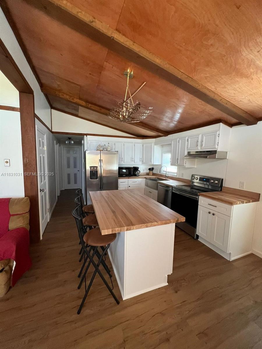 123 Rocky Road Lackawaxen, PA 18435 - Photo 26 of 39 a kitchen with a table chairs wooden floors and a view of kitchen