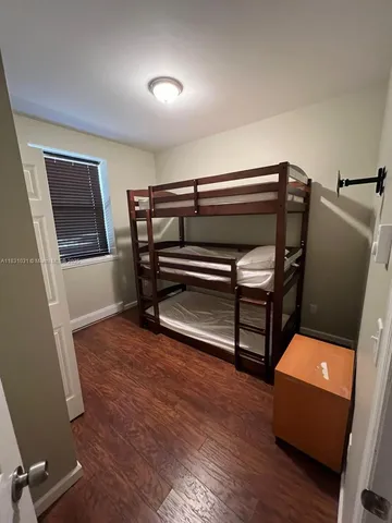 a bed sitting in a bedroom next to a wooden floor