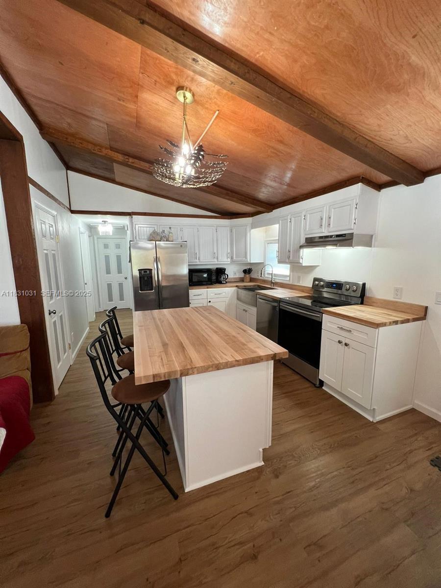 123 Rocky Road Lackawaxen, PA 18435 - Photo 8 of 39 a kitchen with stainless steel appliances granite countertop a table chairs a sink and dishwasher a refrigerator with wooden floor