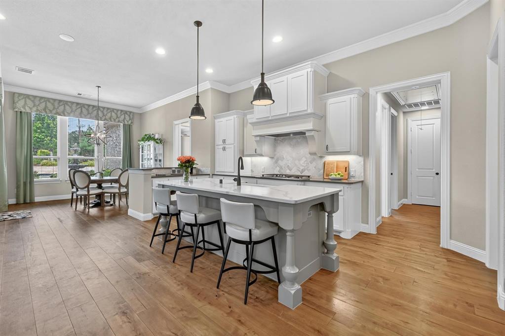 6656 Roughleaf Ridge Road Flower Mound, TX 76226 - Photo 9 of 40 a kitchen with a table chairs stove a sink dishwasher and cabinets with wooden floor