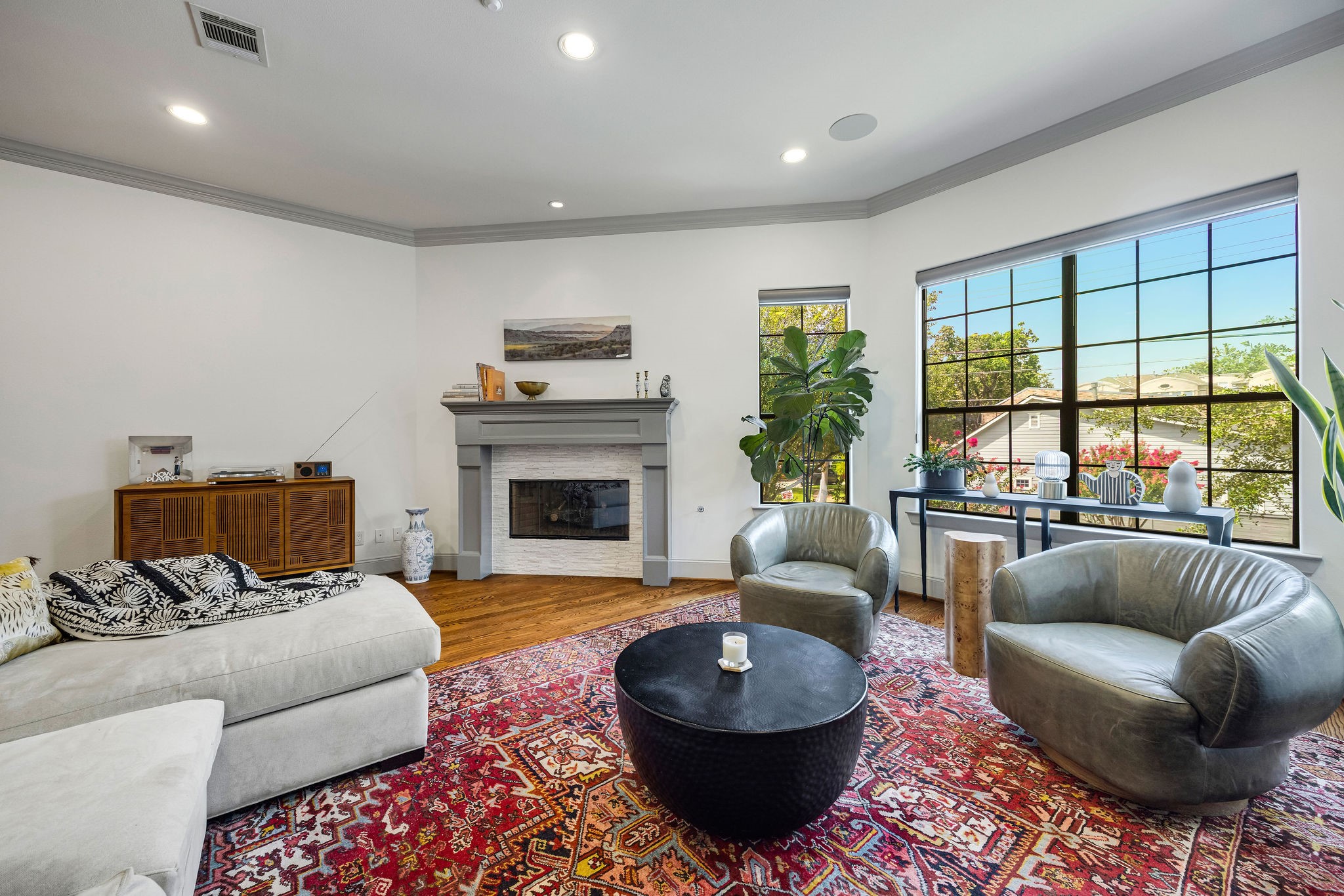 2415 Commonwealth Street Houston, TX 77006 - Photo 3 of 26 The inviting living room is the perfect place to gather, featuring a beautiful fireplace, soaring ceilings, abundant natural light, and plenty of space for both entertaining and relaxing.