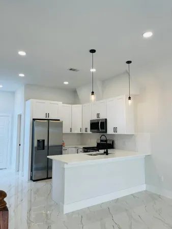 a view of kitchen with stainless steel appliances a refrigerator and a stove top oven