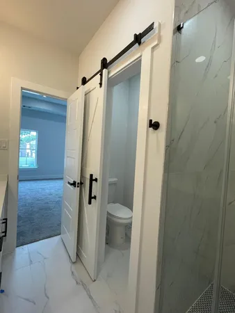 a bathroom with a granite countertop shower and a toilet