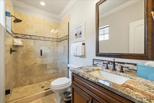 a bathroom with a granite countertop sink toilet and shower