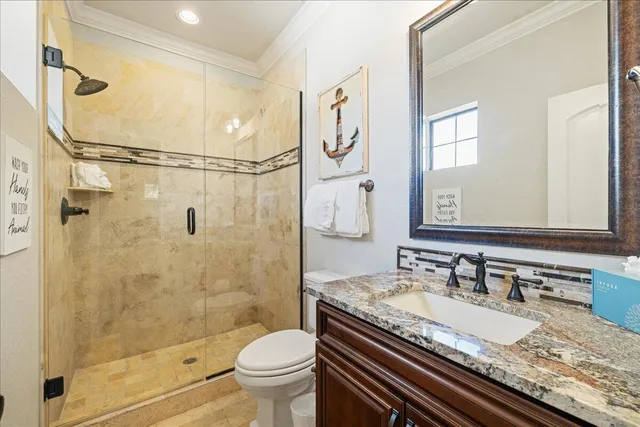 a bathroom with a granite countertop sink a toilet and shower