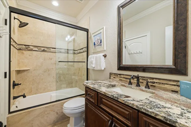 a bathroom with a granite countertop sink toilet and shower
