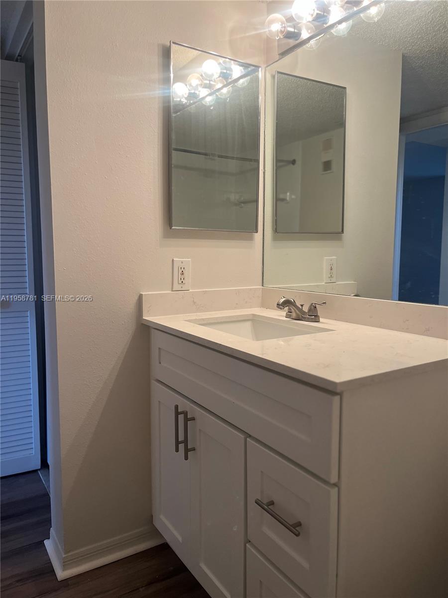 4055 West McNab Road, Unit H211 Pompano Beach, FL 33069 - Photo 13 of 22 a bathroom with a sink vanity and mirror