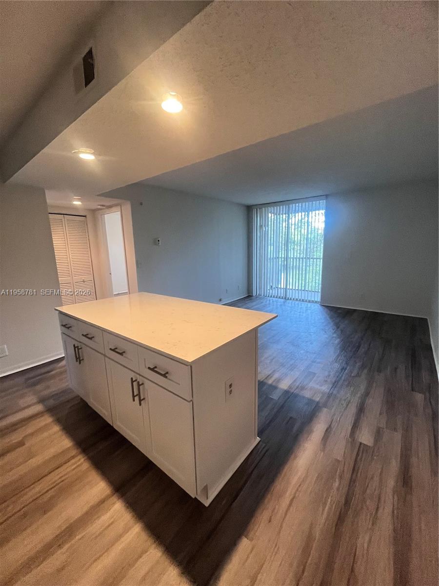 4055 West McNab Road, Unit H211 Pompano Beach, FL 33069 - Photo 2 of 22 a room with wooden floors and white walls