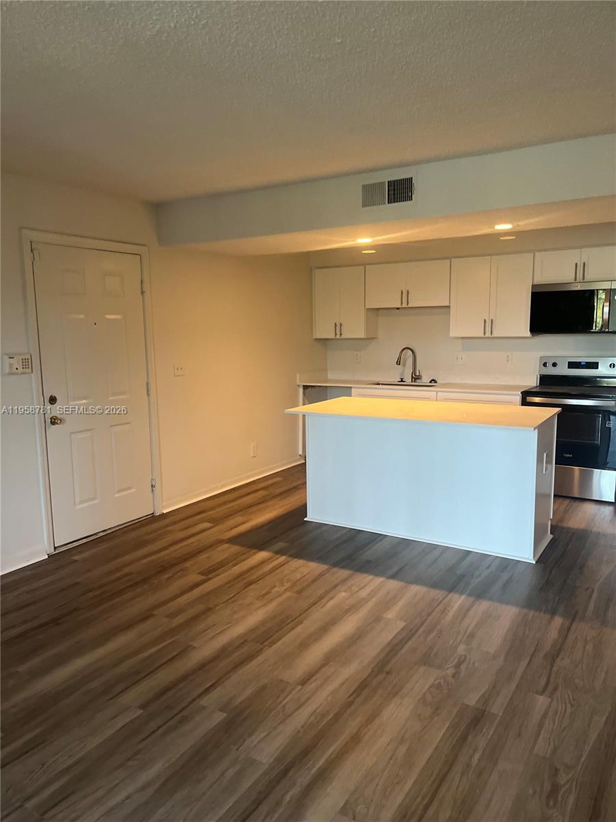 4055 West McNab Road, Unit H211 Pompano Beach, FL 33069 - Photo 7 of 22 a view of kitchen with wooden floor